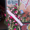 Pink and white floral standing spray with a ribbon on an easel
