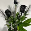 Black roses with green foliage and feathery accents