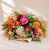 Mixed bouquet of roses, peonies, and hydrangea wrapped in kraft paper