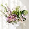 Mixed pastel floral arrangement in a white ribbed container