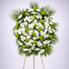 A peaceful white-and-green standing funeral spray featuring white chrysanthemums, green button mums