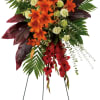 Tall standing floral spray with red and orange flowers on a metal easel