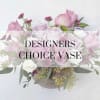 Pink and lavender roses arranged in a vase with small purple blooms