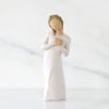 A small, serene sympathy arrangement centered around a softly carved angel figurine-perfect
