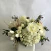 White floral arrangement in a square ceramic vase