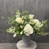White roses and hydrangeas arranged in a gray urn