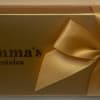 Gold gift box with a satin bow and Emma's Chocolates logo