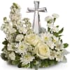 White floral arrangement with a silver cross centerpiece