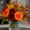Bright orange roses and deep burgundy chrysanthemums set a warm autumn tone