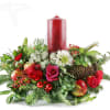 Holiday centerpiece with red candle, roses, and evergreen accents