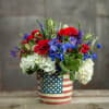 Red, blue, and white flowers in an American flag tin container