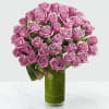 Pink roses arranged in a tall glass vase with a ribbon
