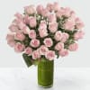 Pink roses arranged in a tall green vase