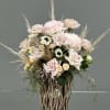 Blush rose arrangement in a tall decorative vase