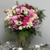 Bouquet of pink, purple, and white flowers in a woven vase