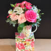 Pink and peach roses with white alstroemeria in a floral mug on a matching box