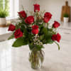 Red roses arranged in a clear glass vase