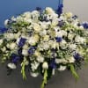 Large white and blue floral arrangement in a dark container