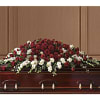 Red and white rose casket spray on a wooden casket