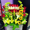 Mixed bouquet of red and cream roses with yellow lilies in a wooden box