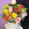 Mixed bouquet of roses and daisies in a white basket