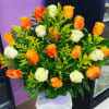 Bouquet of orange and white roses in a lavender container