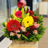 Mixed bouquet with red roses, gerbera daisies, lilies, and pink flowers in a wooden box