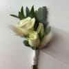 Small white rose boutonniere with gray foliage and soft feather accents