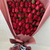 Large bouquet of red roses wrapped in pink paper with a striped ribbon