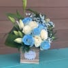 Blue and white roses with lily buds in a wooden box
