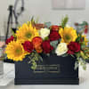 Sunflowers and roses arranged in a black box