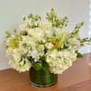 White floral arrangement in a green glass vase