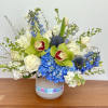 Blue and white floral arrangement in a gray vase