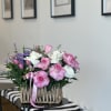 Pink and white roses arranged in a woven basket