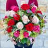 Large bouquet of red, pink, and white roses in a clear vase