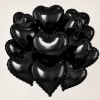 Cluster of black heart-shaped balloons on a plain background
