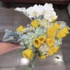 Bouquet of yellow tulips, white orchids, and pale blue hydrangeas