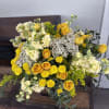 Yellow roses and cream flowers arranged in a bouquet