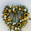 Open heart is an assortment of sunflowers, yellow roses and carnations, white
