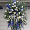 Tall standing floral spray with white roses, blue delphinium, and white orchids