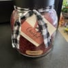 Jar candle with a black-and-white ribbon and cranberry orange label