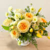Yellow and cream roses arranged in a white vase