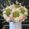 Pink and white roses with green hydrangeas in a white hatbox
