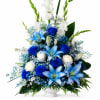 Blue and white floral arrangement in a white vase with lilies and roses