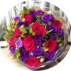 A bold hand-tied flower arrangement that pairs vivid red roses with deep
