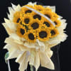 Bouquet of sunflowers wrapped in cream paper with a ribbon