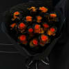 Bouquet of orange roses wrapped in black paper