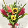 Tropical bouquet with sunflowers and pink ginger in a glass vase
