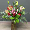 Bouquet of red roses and pink lilies in a glass vase