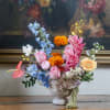 Colorful mixed flower arrangement in a striped ceramic vase